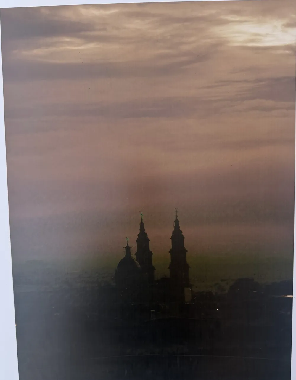 Las torres y la cúpula de la parroquia en silueta al atardecer